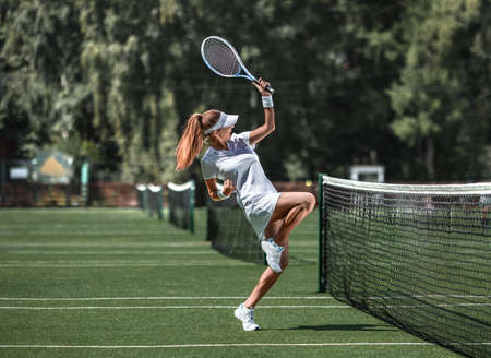 Happy young girl on the tennis courtの写真素材