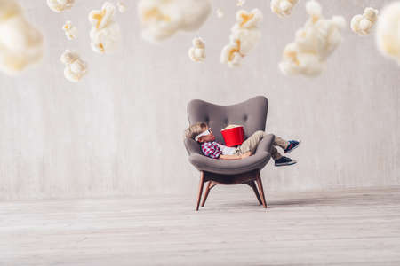 Sleeping little boy with popcorn in cinemaの写真素材
