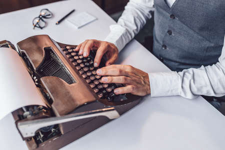 Male hands typing on a retro typewriter close-upの写真素材