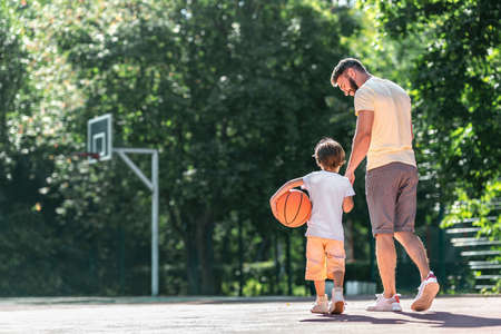 Young family with a ball on the basketball courtの写真素材