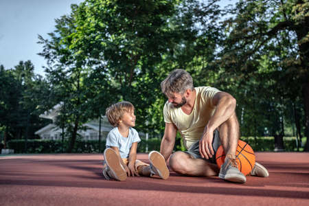Father and son on the basketball court near the houseの写真素材
