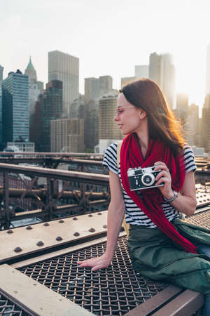 Smiling girl with a camera on Brooklyn Bridge in New Yorkの写真素材