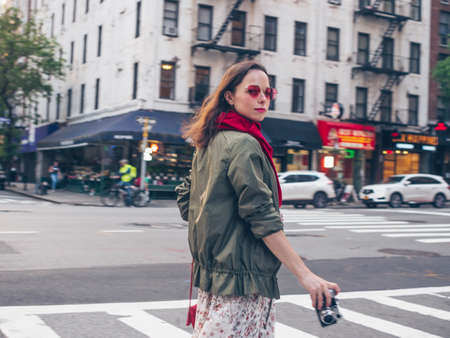 Beautiful girl with a retro camera in New York