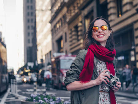 Smiling girl with a retro camera in Manhattanの写真素材
