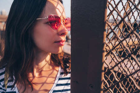 Young woman with a red glasses in sunlight