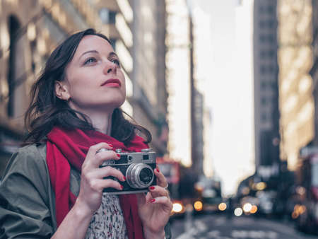 Young girl with a retro camera in Manhattanの写真素材