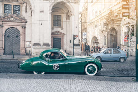 Green retro car on the street of Pragueの写真素材