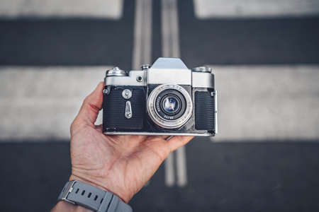 Men's hands with a retro camera on the backgroundの写真素材
