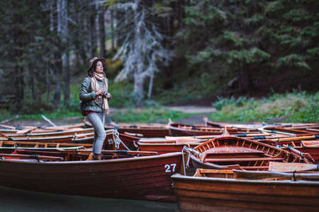 Young woman with a retro camera in a wooden boat