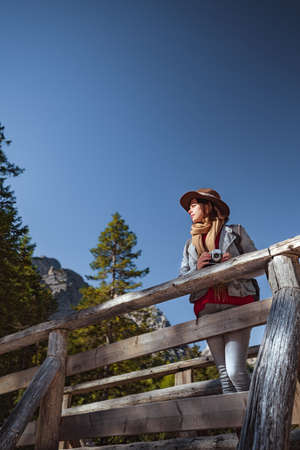 Young photographer with a retro camera on a wooden bridgeの写真素材