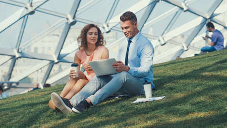 Working couple with laptop on a grassの写真素材