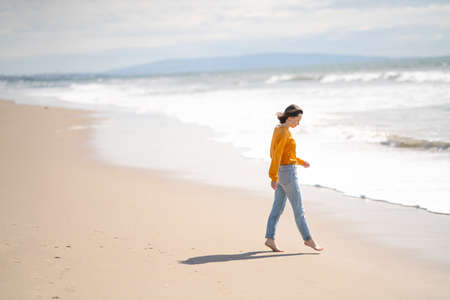 Young barefoot girl on the beach in Los Angelesの写真素材