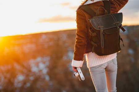Young woman with a retro camera in the sunset at the Grand Canyon, USAの写真素材