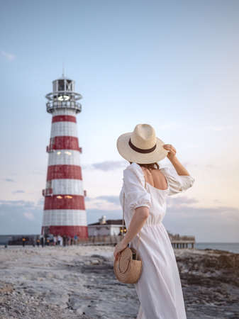 Young woman in a white dress at the beaconの写真素材