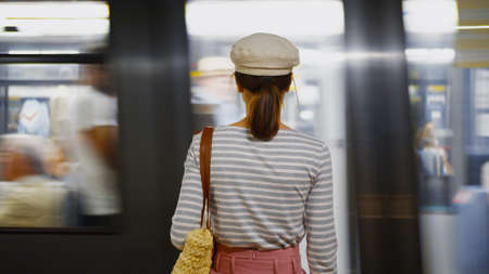Young woman waiting for a train in the subway in Paris