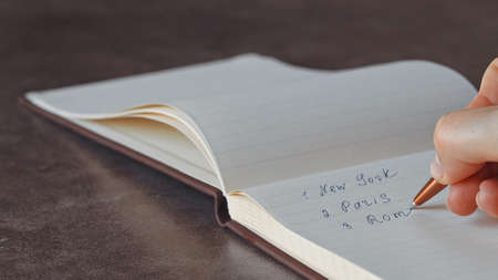 Female hand writing in notebook close-upの写真素材