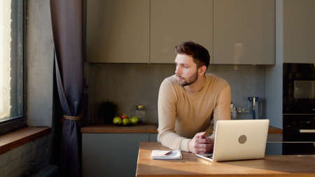 Portrait of a young man thinking ideas for his business at home office. Young man laptop in the...