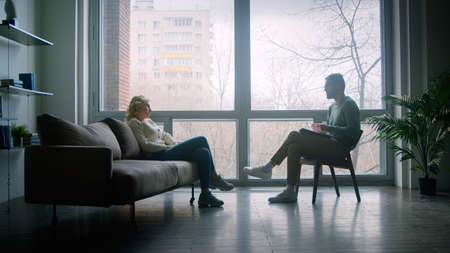 Young doctor listening to the story of the patient at the psychological session in the officeの写真素材