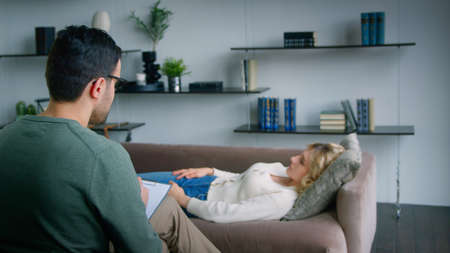 Young woman on the couch talking about her problem indoorsの写真素材