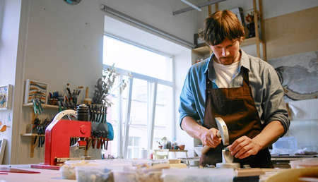 Young man working with mosaic in a creative studioの写真素材