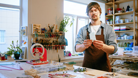 Young master with a piece of glass in creative workshopの写真素材