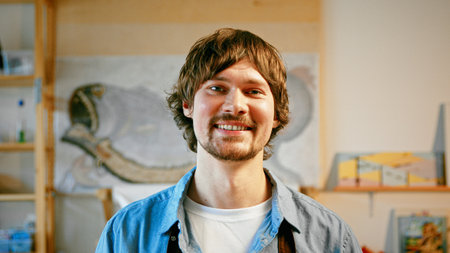 Smiling man in an apron looking at camera in studioの写真素材