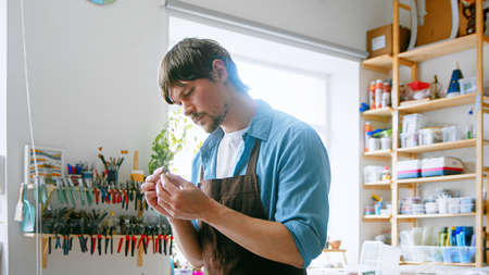 Young master in an apron at work in his workshopの写真素材