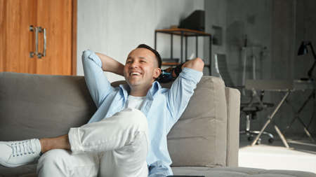 Smiling cyborg guy with bio limb prothesis with cheerful laughter at homeの写真素材