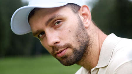 Portrait of a young man in a cap playing golf on the fieldの写真素材