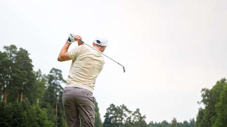 Young sportsman playing golf on the fieldの写真素材