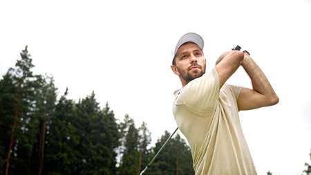Young male playing golf on the fieldの写真素材