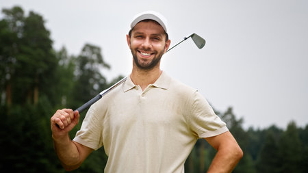 Portrait of a young golfer in uniform looking at camera on the fieldの写真素材