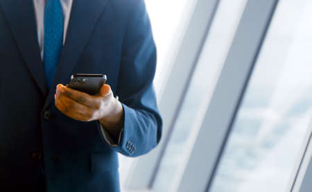 Young businessman in a suit using a smartphone in the office. business concept close upの写真素材