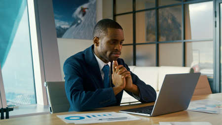 Young man in a suit typing on a laptop. Young businessman working in the officeの写真素材