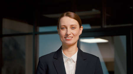 Young businesswoman smiling and looking at camera. Young woman in a suit in the officeの写真素材