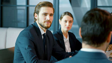 Corporate business team in a meeting with a manager. Young group of diverse people indoorsの写真素材