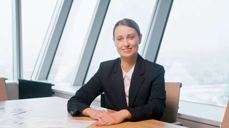 Young girl in a suit discussing via video call in the office. young businesswoman at video conferenceの写真素材