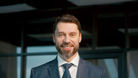 Mature businessman smiling and looking at camera. Mature man in a suit in the officeの写真素材