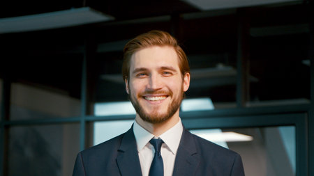 Young businessman smiling and looking at the camera. Young man in a suit in the officeの写真素材