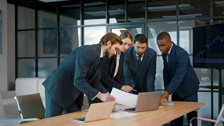 Young people in suits discussing in the office. Corporate business team in a meetingの写真素材