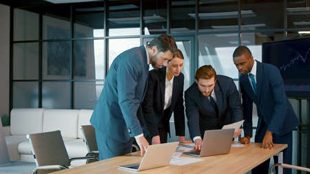 Young people in suits discussing in the office. Corporate business team in a meetingの写真素材