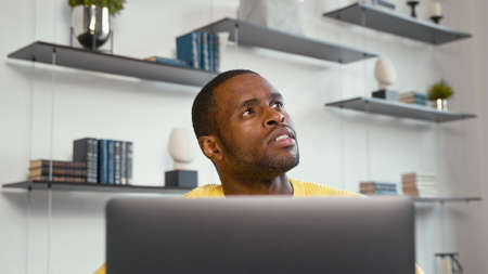 Young professional man working with laptop at the desk at homeの写真素材