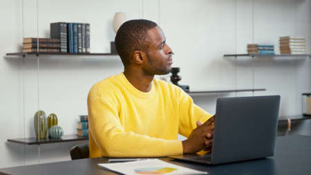Young man thinking about a new idea for your business. Thinking young male at the desk in home officeの写真素材