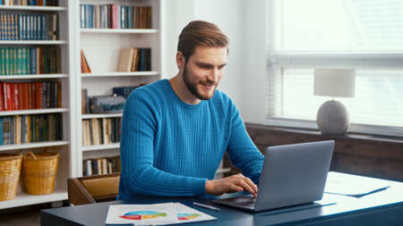 Male professional typing on laptop keyboard at office workplaceの写真素材