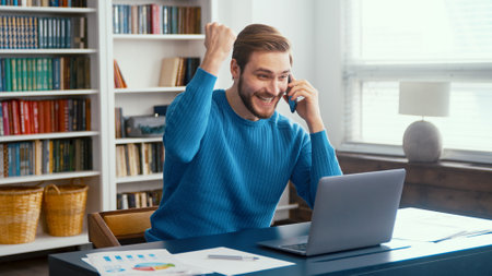A successful man reacts emotionally to the news indoorsの写真素材