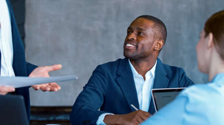 Young colleagues applauding business leader after speaking at a meeting in the office