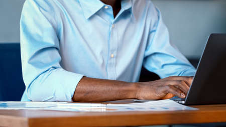 Young African American man working on laptop at home officeの写真素材