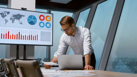 Young attractive businessman working with laptop in meeting roomの写真素材