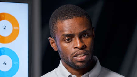 Young afro american businessman listening to questions at presentation in meeting room