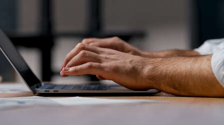 Young businessman typing corporate company official letter on computer in office, close-upの写真素材